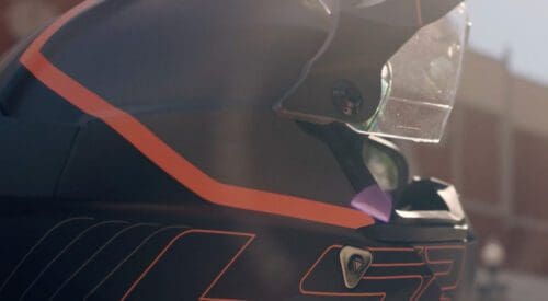 LS2 brand helmet sitting on the ground with the sun hitting the eye mask.